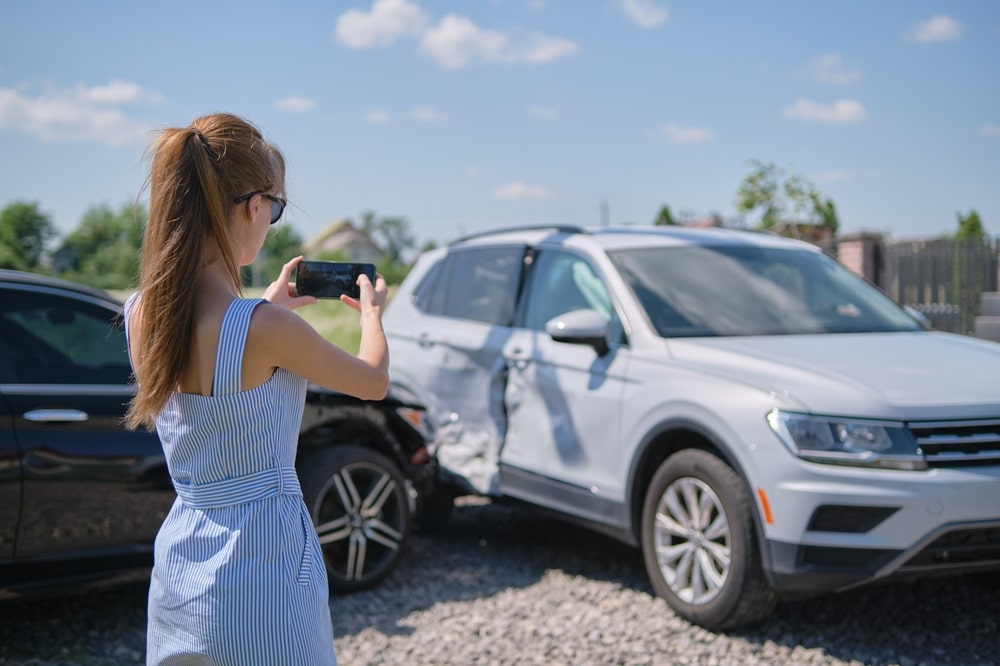 Woman taking a photo of a car accident