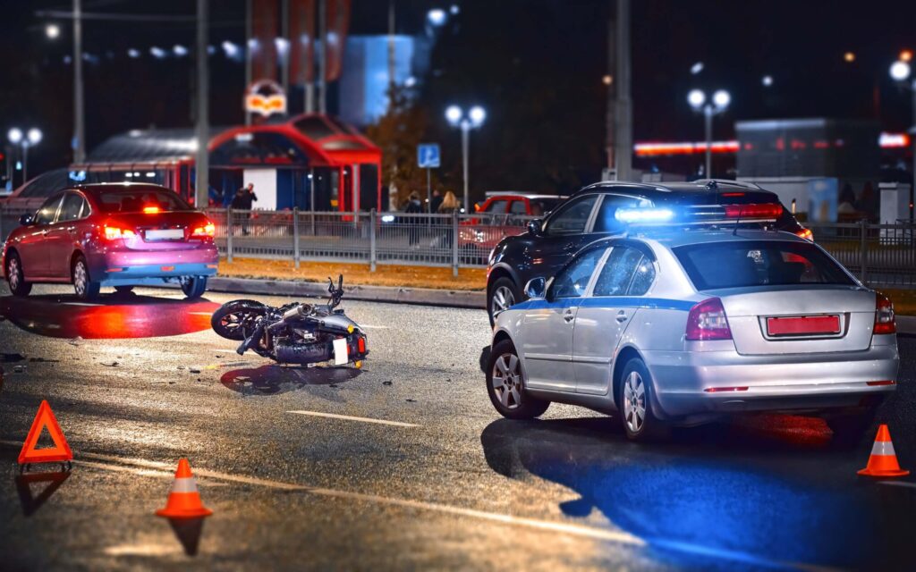 Traffic police car with blue flashing lights investigates motorcycle collision