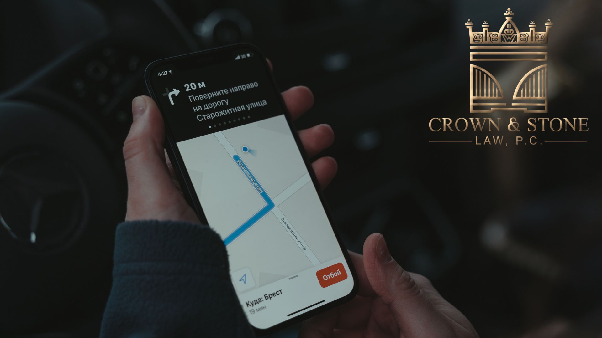 Hand holding smartphone with GPS navigation in car