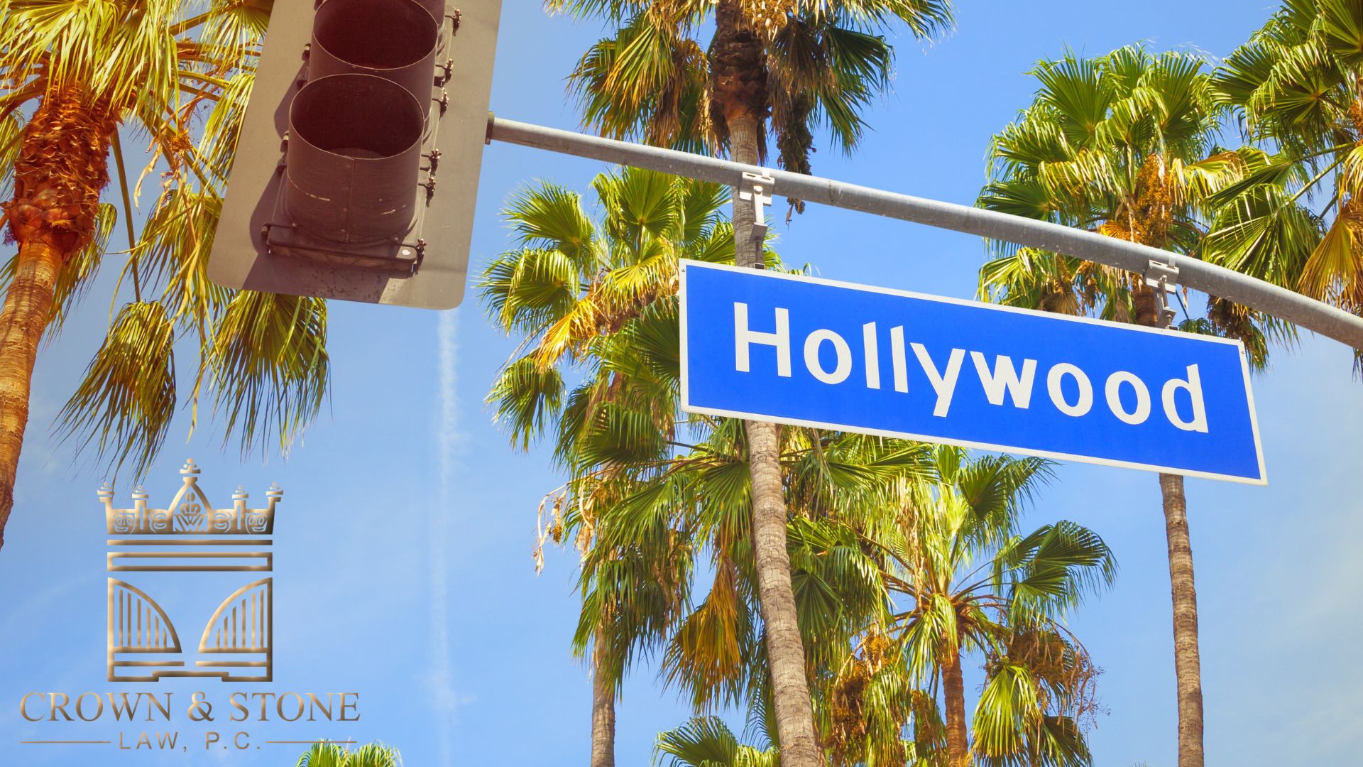 Hollywood street sign with palm trees and traffic light