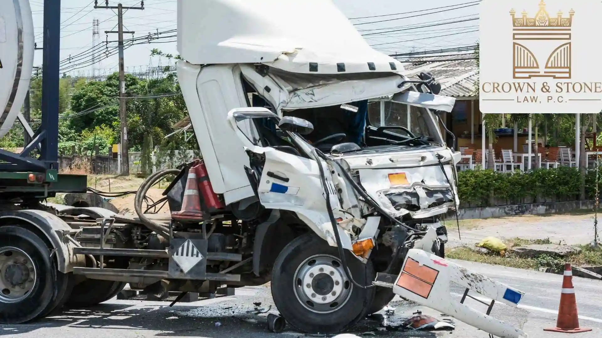 Severely damaged white truck beside roadside law firm sign